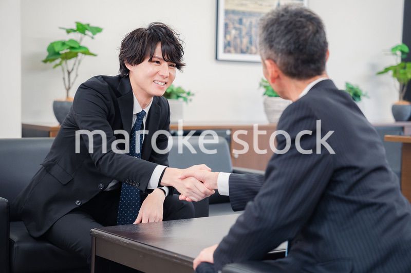 B2B商談で握手を交わすビジネスマン
