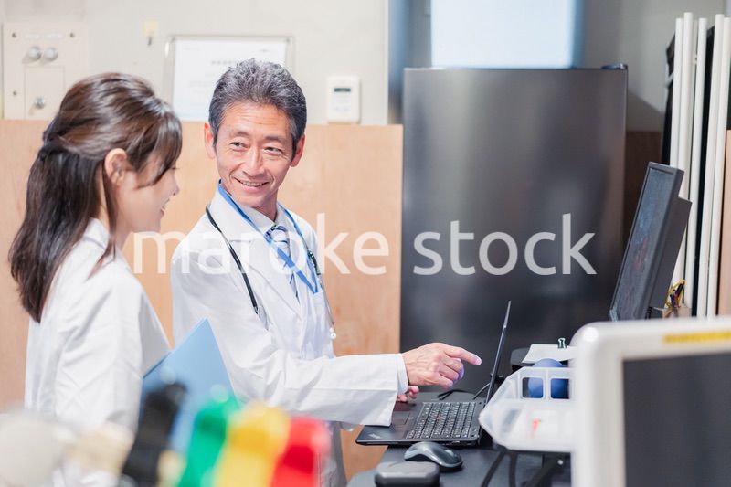 ナースステーションで打ち合わせをする医療従事者たち