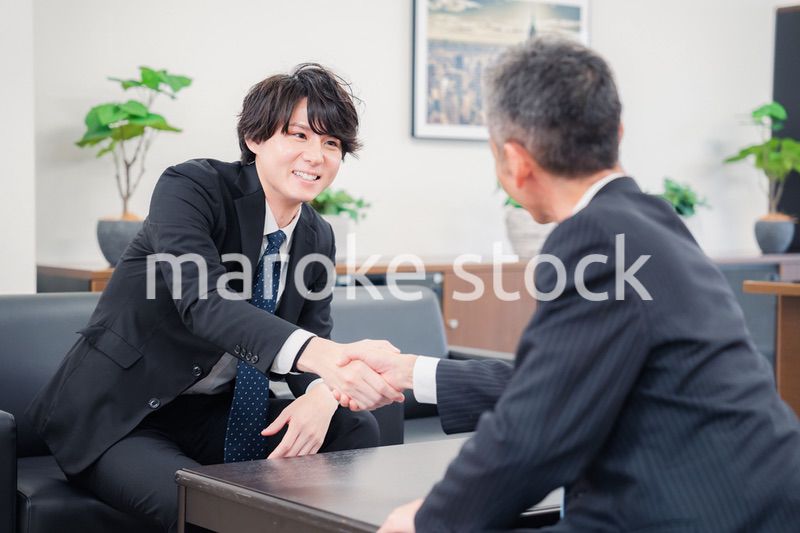 B2B商談で握手を交わすビジネスマン