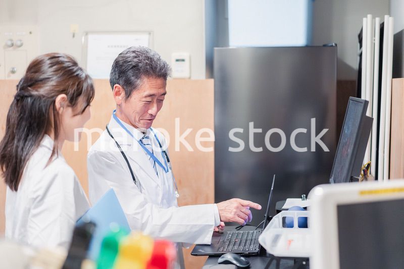 ナースステーションで打ち合わせをする医療従事者たち