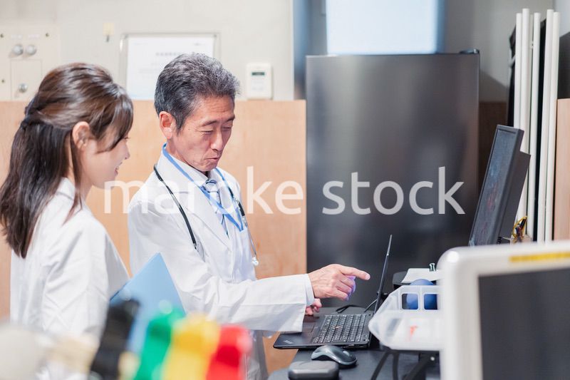 ナースステーションで打ち合わせをする医療従事者たち