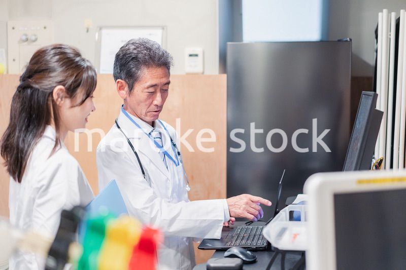 ナースステーションで打ち合わせをする医療従事者たち