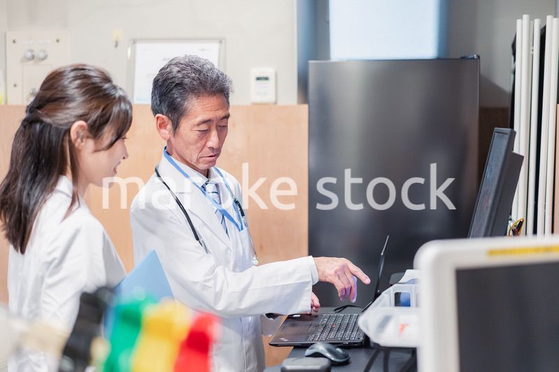 ナースステーションで打ち合わせをする医療従事者たち