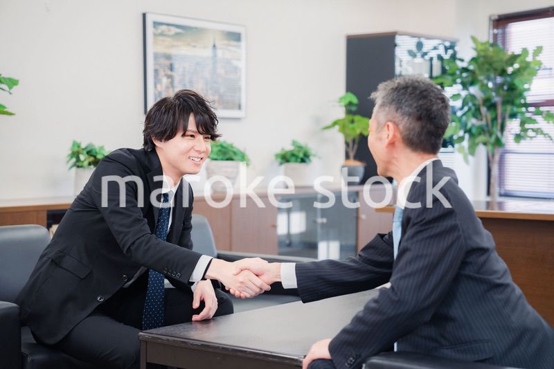 B2B商談で握手を交わすビジネスマン