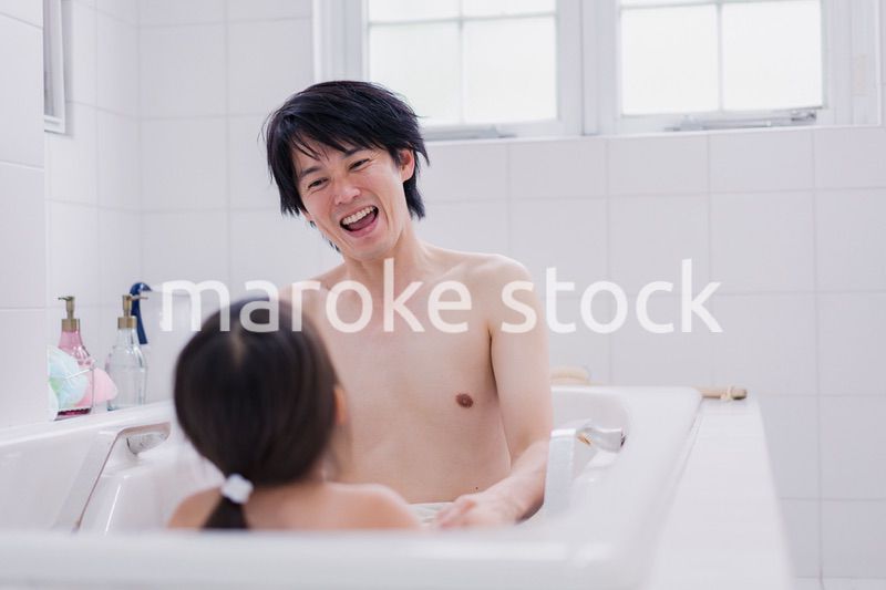 小さな娘と一緒にお風呂に入るお父さん