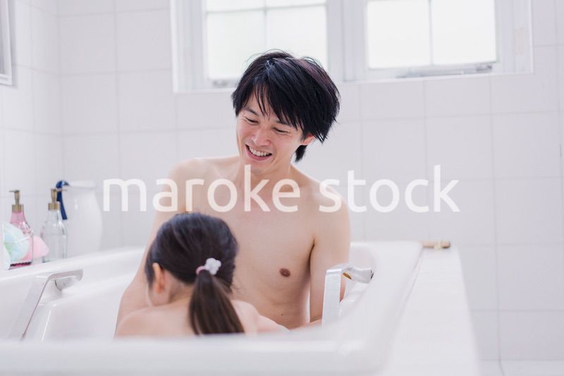小さな娘と一緒にお風呂に入るお父さん