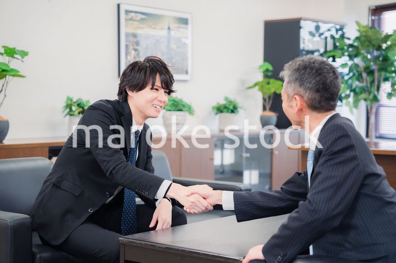 B2B商談で握手を交わすビジネスマン
