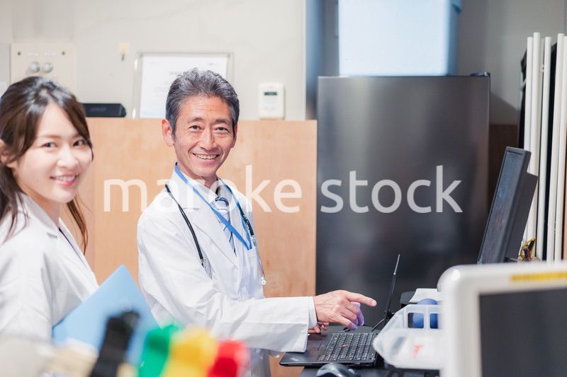 ナースステーションで打ち合わせをする医療従事者たち