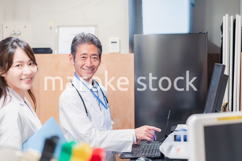 ナースステーションで打ち合わせをする医療従事者たち