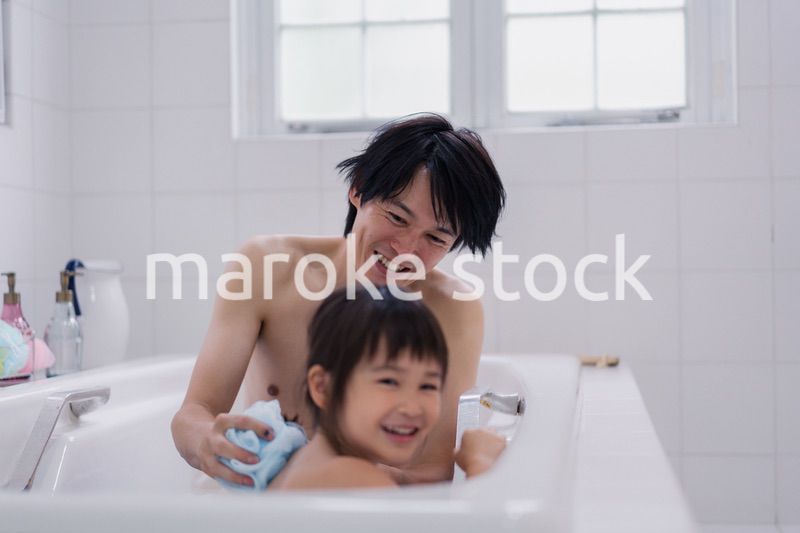 小さな娘と一緒にお風呂に入るお父さん