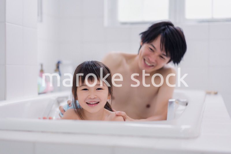 小さな娘と一緒にお風呂に入るお父さん