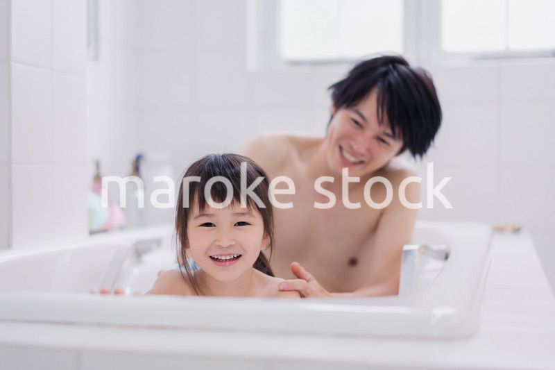 小さな娘と一緒にお風呂に入るお父さん