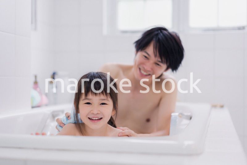 小さな娘と一緒にお風呂に入るお父さん
