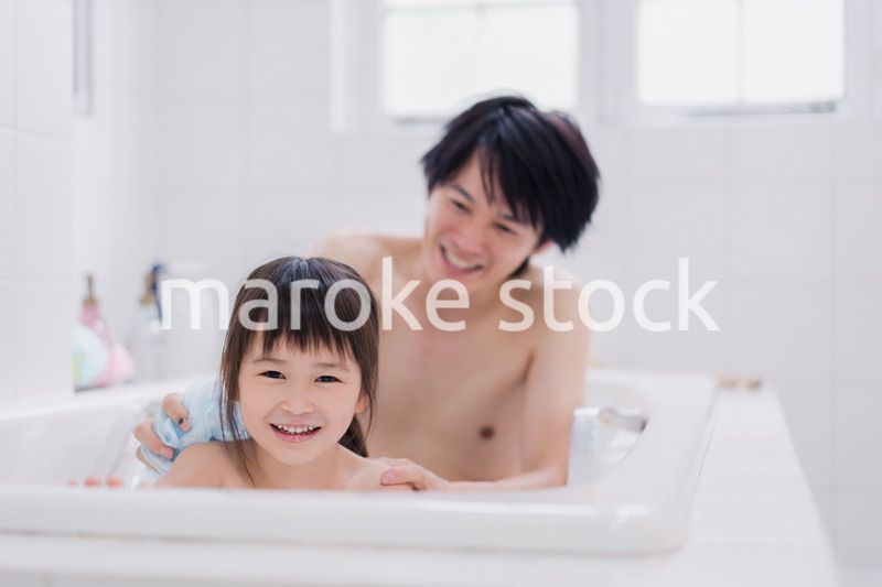 小さな娘と一緒にお風呂に入るお父さん