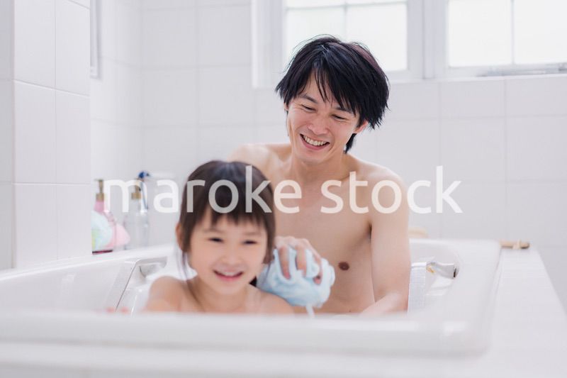 小さな娘と一緒にお風呂に入るお父さん