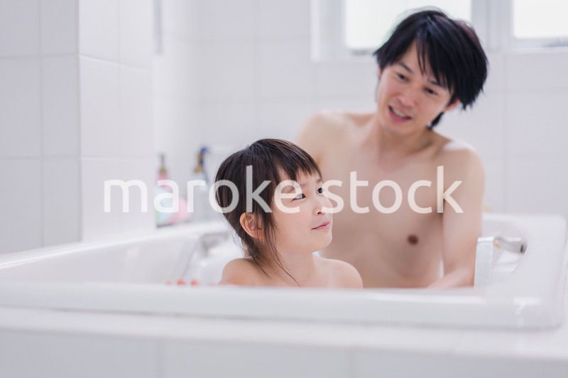 小さな娘と一緒にお風呂に入るお父さん