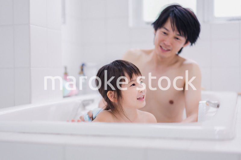小さな娘と一緒にお風呂に入るお父さん