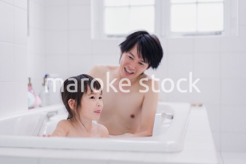 小さな娘と一緒にお風呂に入るお父さん
