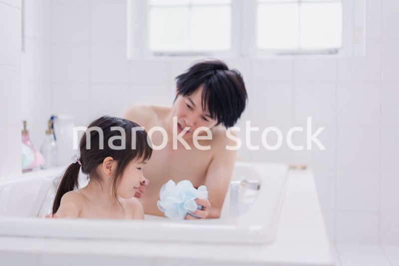 小さな娘と一緒にお風呂に入るお父さん