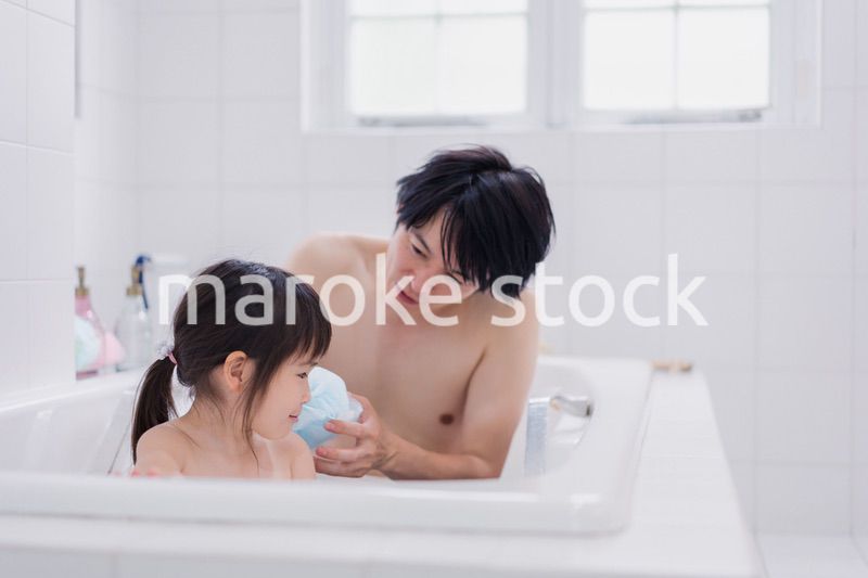 小さな娘と一緒にお風呂に入るお父さん