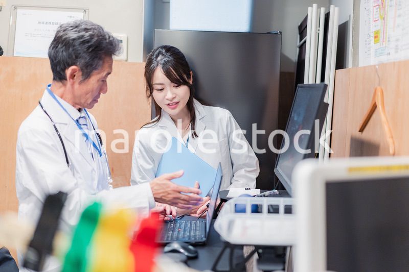 ナースステーションで打ち合わせをする医療従事者たち