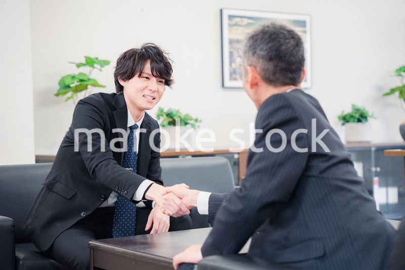 B2B商談で握手を交わすビジネスマン