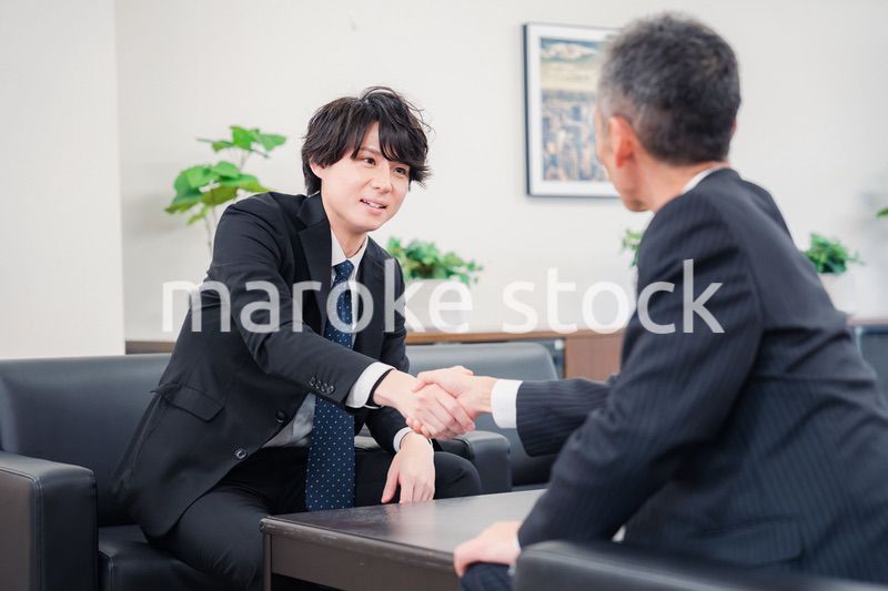 B2B商談で握手を交わすビジネスマン