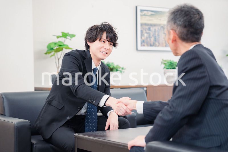 B2B商談で握手を交わすビジネスマン