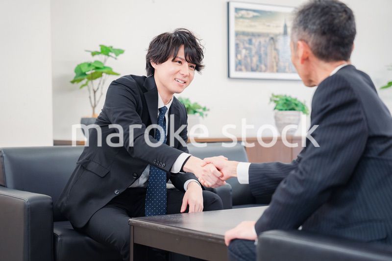 B2B商談で握手を交わすビジネスマン