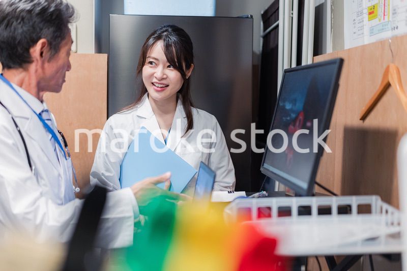 ナースステーションで打ち合わせをする医療従事者たち