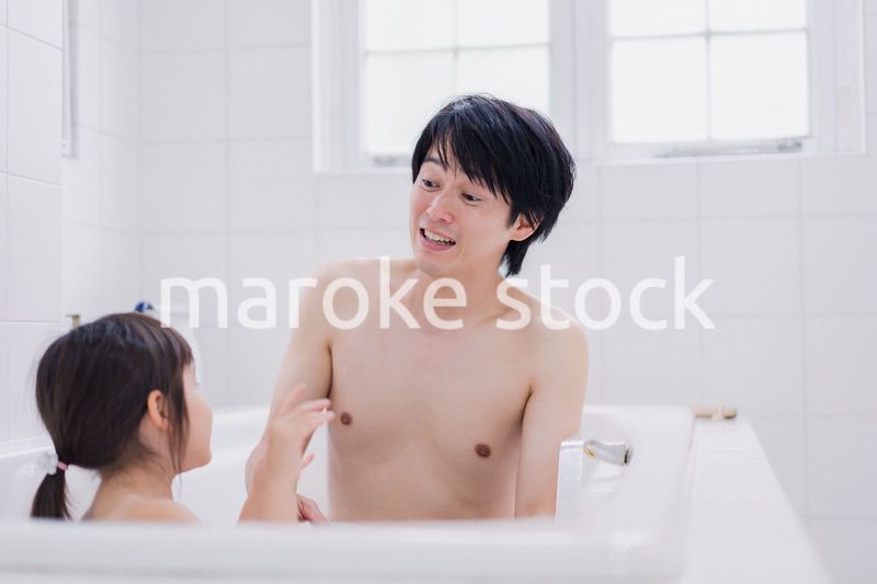 小さな娘と一緒にお風呂に入るお父さん