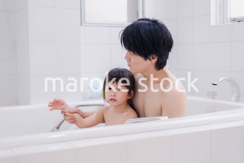 小さな娘と一緒にお風呂に入るお父さん