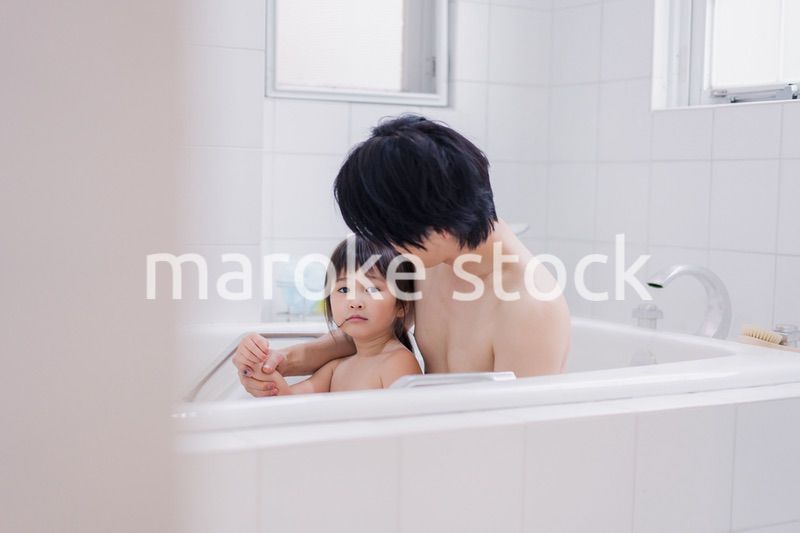 小さな娘と一緒にお風呂に入るお父さん