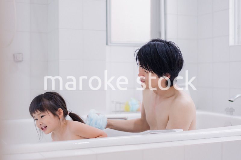 小さな娘と一緒にお風呂に入るお父さん