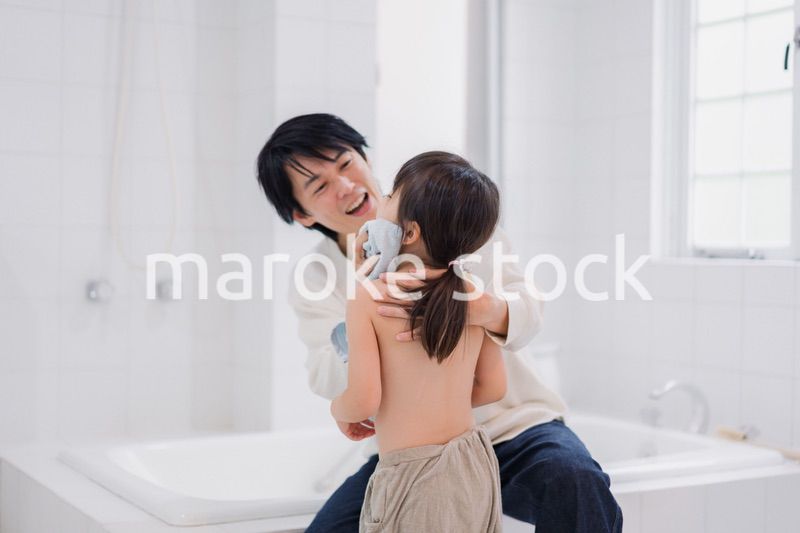 お風呂で娘の体を拭くお父さん