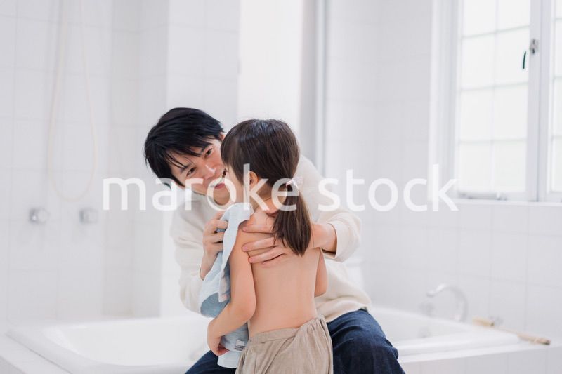 お風呂で娘の体を拭くお父さん