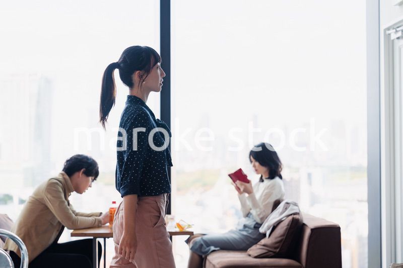 モダンな雰囲気のオフィスのカフェテリアを歩くキャリアウーマン