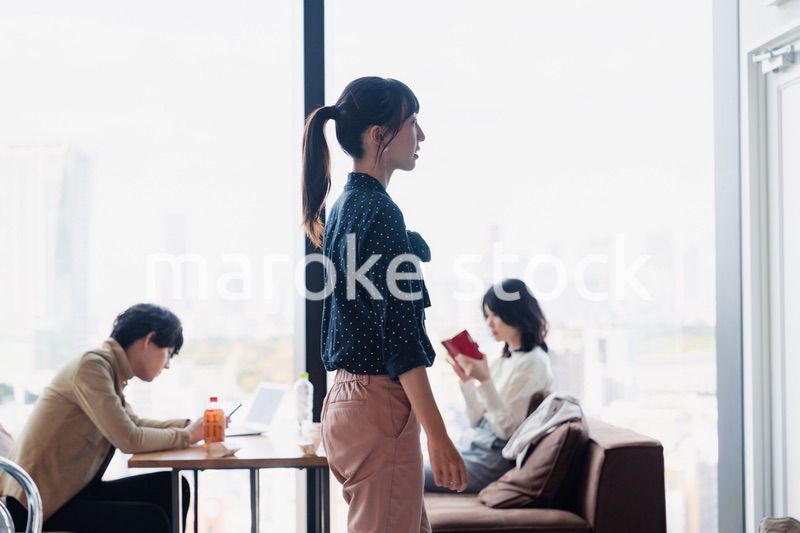 モダンな雰囲気のオフィスのカフェテリアを歩くキャリアウーマン