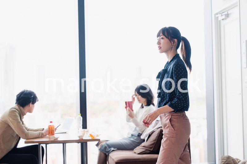 モダンな雰囲気のオフィスのカフェテリアを歩くキャリアウーマン