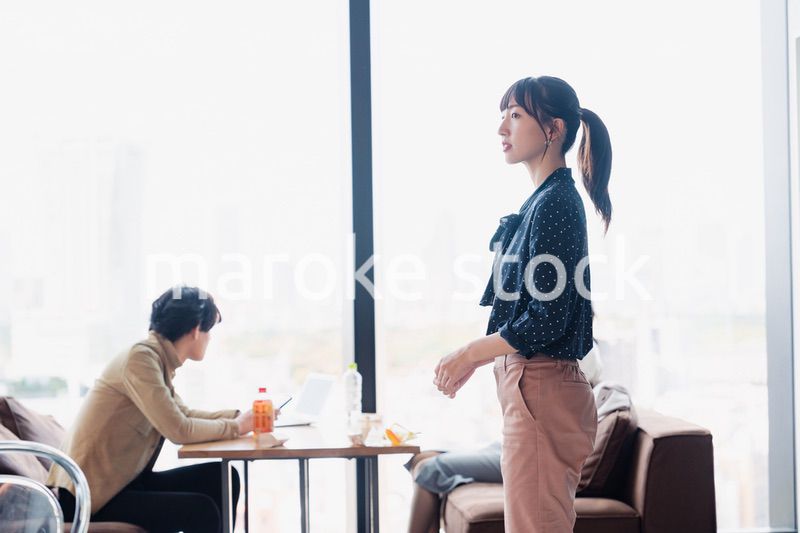 モダンな雰囲気のオフィスのカフェテリアを歩くキャリアウーマン