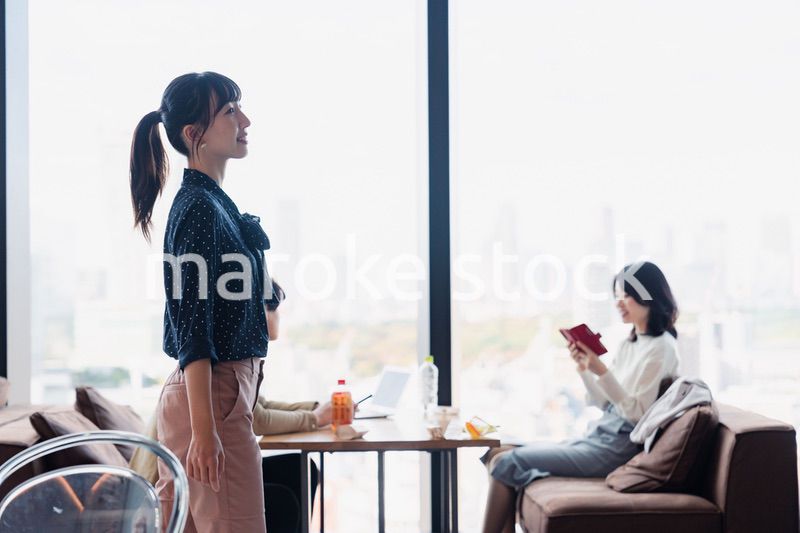 モダンな雰囲気のオフィスのカフェテリアを歩くキャリアウーマン