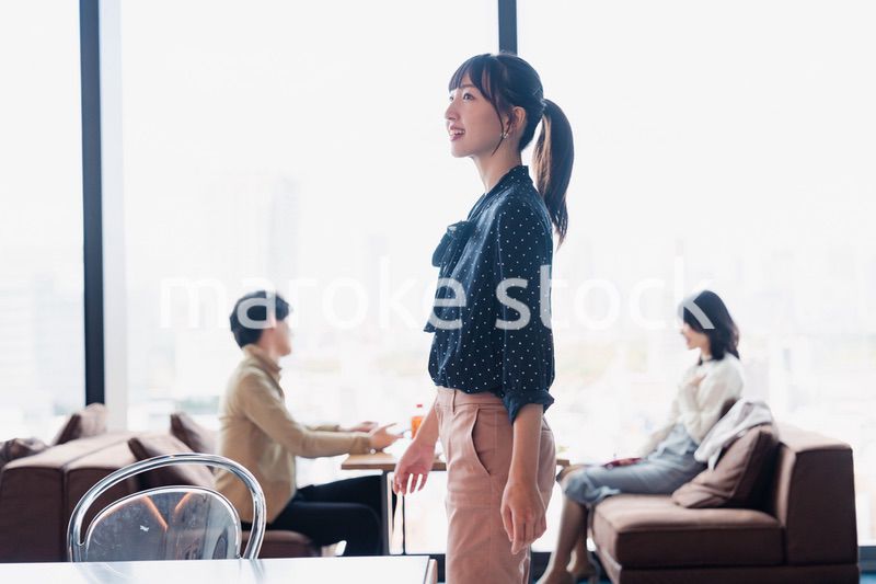 モダンな雰囲気のオフィスのカフェテリアを歩くキャリアウーマン