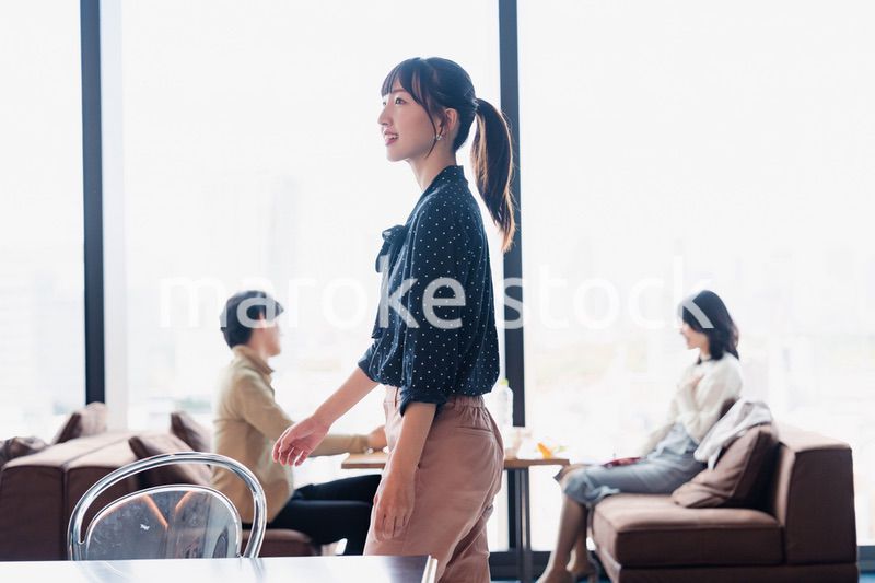 モダンな雰囲気のオフィスのカフェテリアを歩くキャリアウーマン
