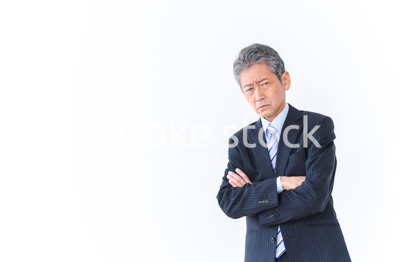 腕を組み厳しい表情をするビジネスマン