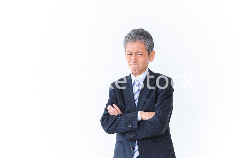 腕を組み厳しい表情をするビジネスマン