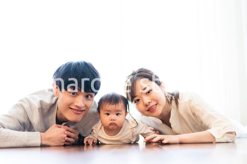 赤ちゃんと一緒に寝転ぶファミリー
