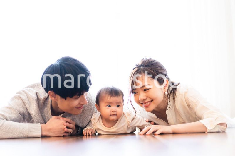赤ちゃんと一緒に寝転ぶファミリー