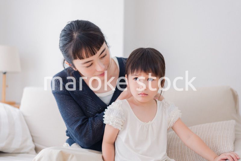 娘の髪を結ぶお母さん