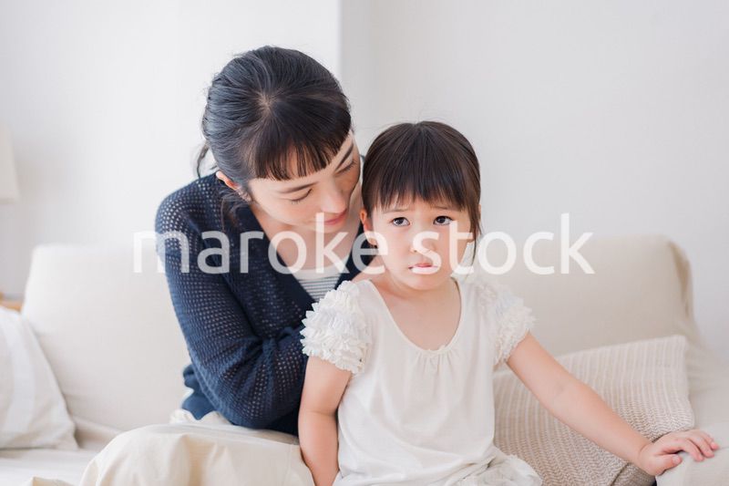 娘の髪を結ぶお母さん