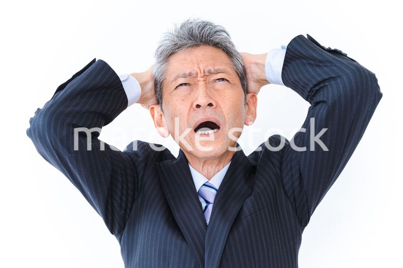 頭を抱える中年のビジネスマン
